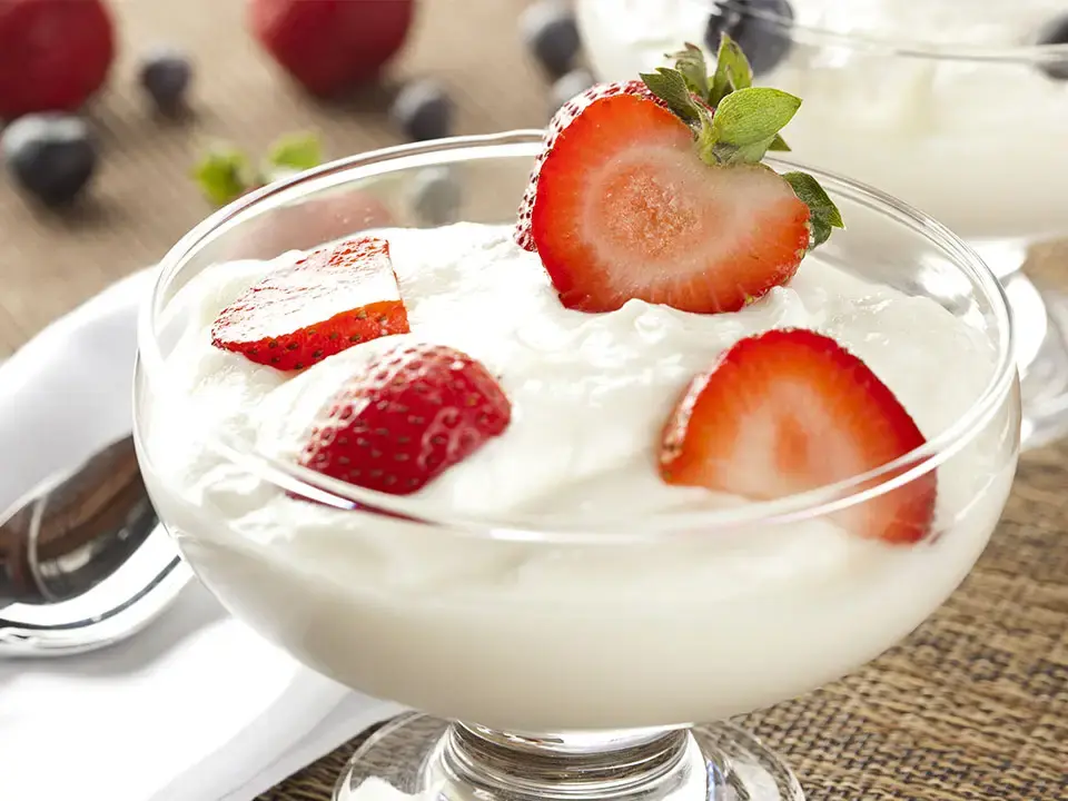 Bowl of yogurt topped with fresh strawberries