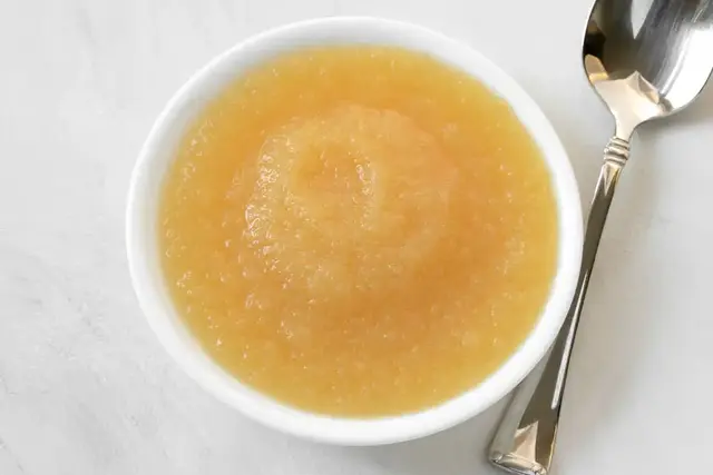 Bowl of smooth applesauce with a spoon