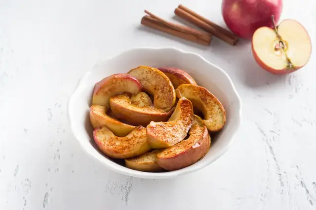 Baked apple slices with cinnamon in a bowl