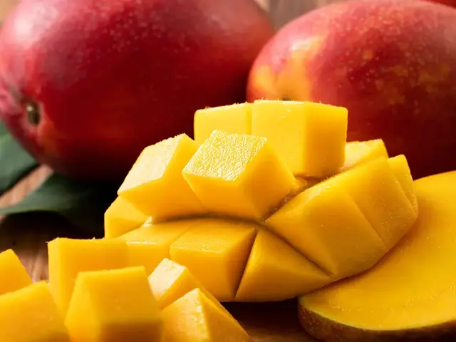Ripe mangoes with one cut into cubes