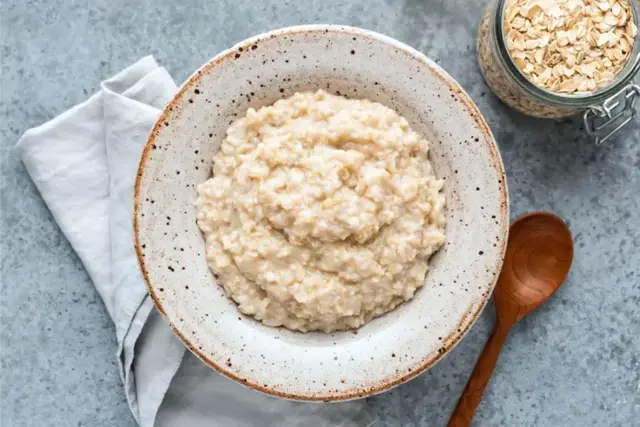 Bowl of oatmeal with a wooden spoon