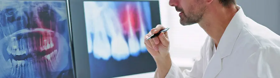 Dentista revisando radiografías dentales en una pantalla