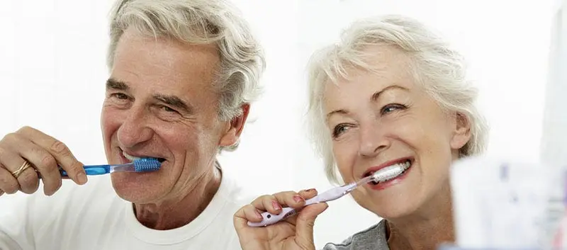 Older couple brushing their teeth together