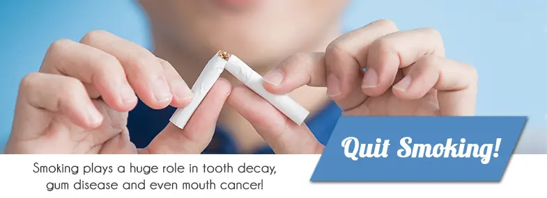 Hands breaking a cigarette in half: smoking plays a huge role in tooth decay, gum disease and even mouth cancer