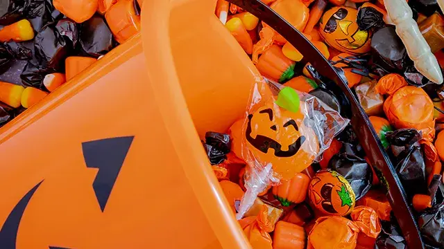 Jack-o’-lantern bucket spilling Halloween candy