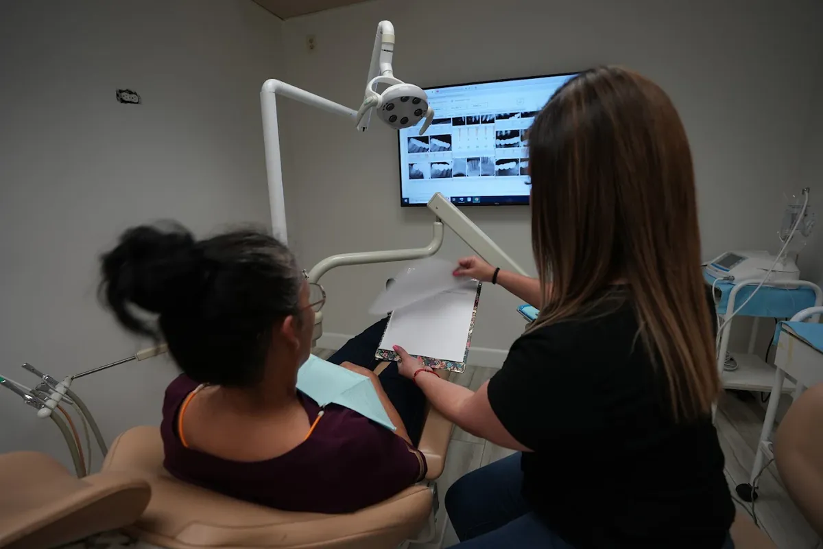 Patient in the dental chair talking with a team member