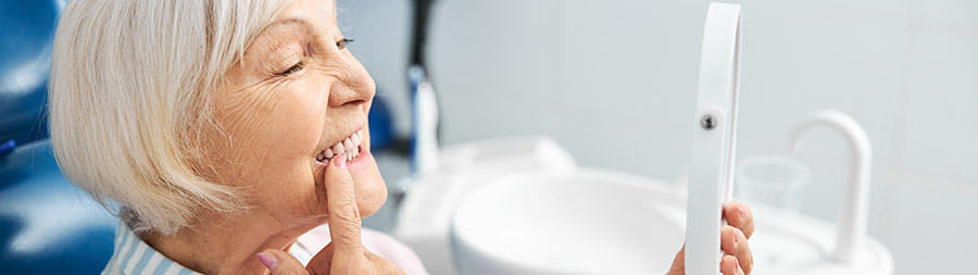 Mujer paciente sonriendo con nuevos implantes dentales