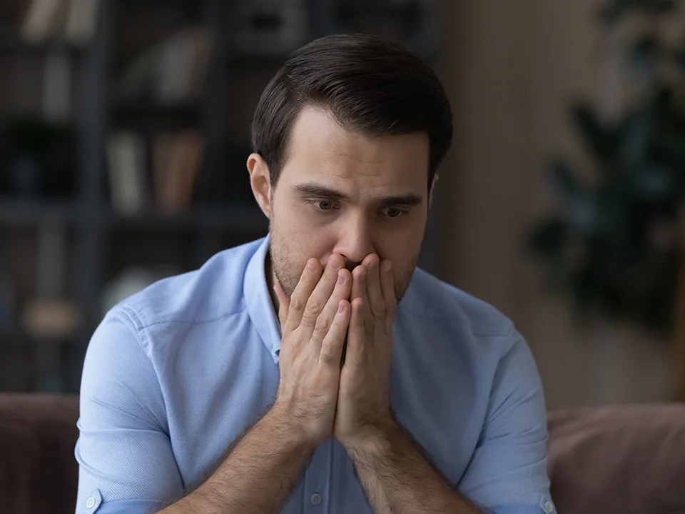Man Covering Missing Teeth with Hands